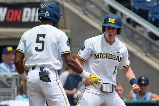 Michigan first baseman Jimmy Kerr (15) celebrates scoring in the first inning with Wolverines outfielder Christan Bullock (5) against Texas Tech in the 2019 College World Series at TD Ameritrade 