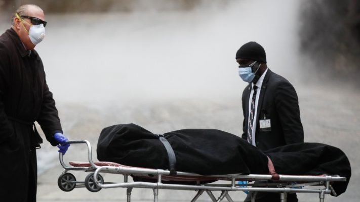 A funeral director wears personal protective equipment due to COVID-19 concerns while collecting a body at The Brooklyn Hospital Center, Thursday, April 9, 2020, in the Brooklyn borough of New York [John Minchillo/AP Photo]