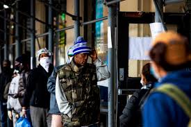 Social distancing has meant customers, such as people at a bank this month in New York, line up outside establishments and wear masks. (Demetrius Freeman for The Washington Post)