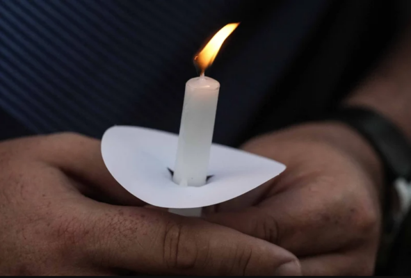 Mark Gorman holds a candle during a candlelight vigil for the slain students and teachers at Apalachee High School